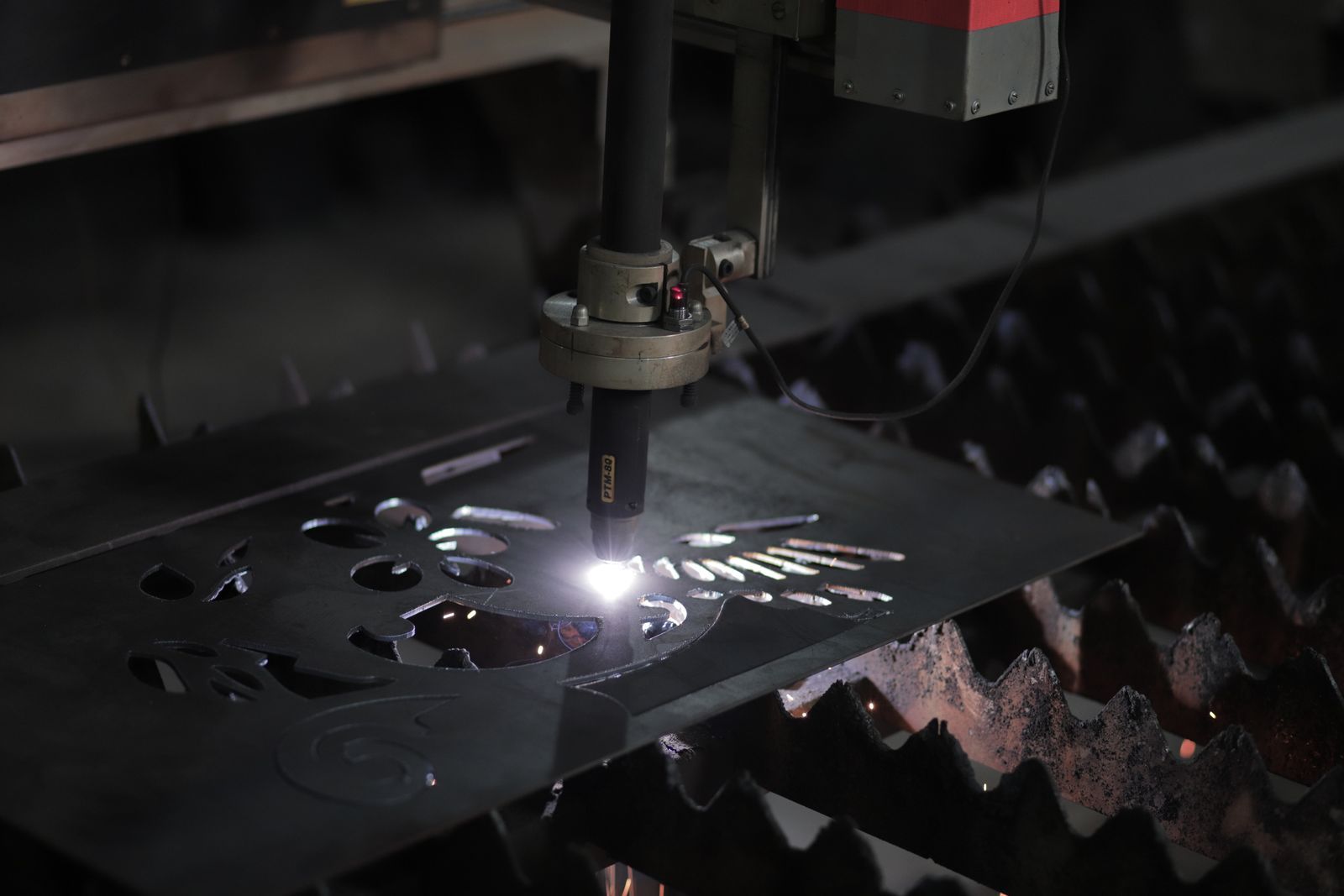 Obor plasma memotong pola pada plat baja